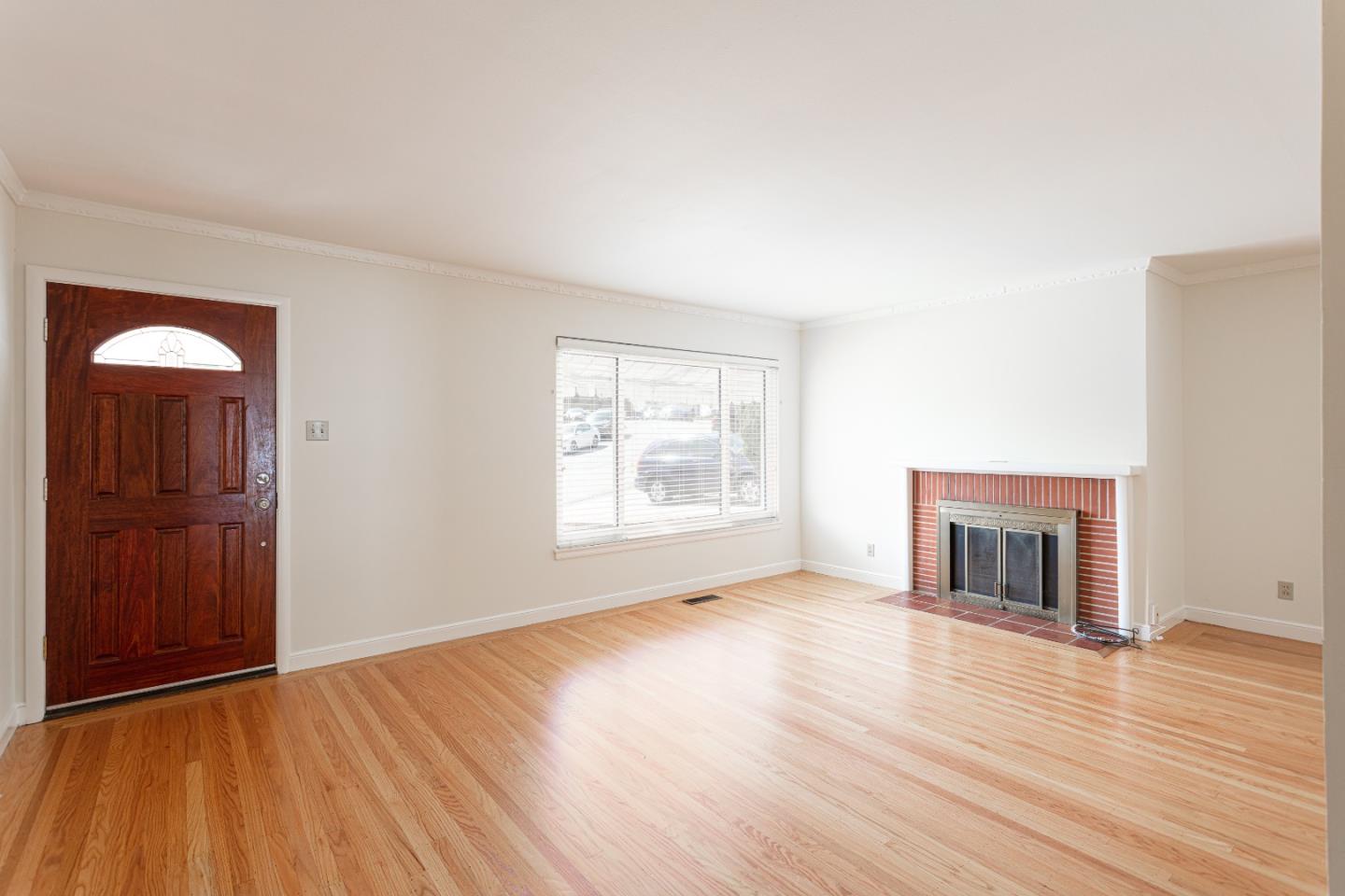 20 Fairview Place Millbrae, CA 94030 - Photo 4 of 21 an empty room with wooden floor fireplace and windows