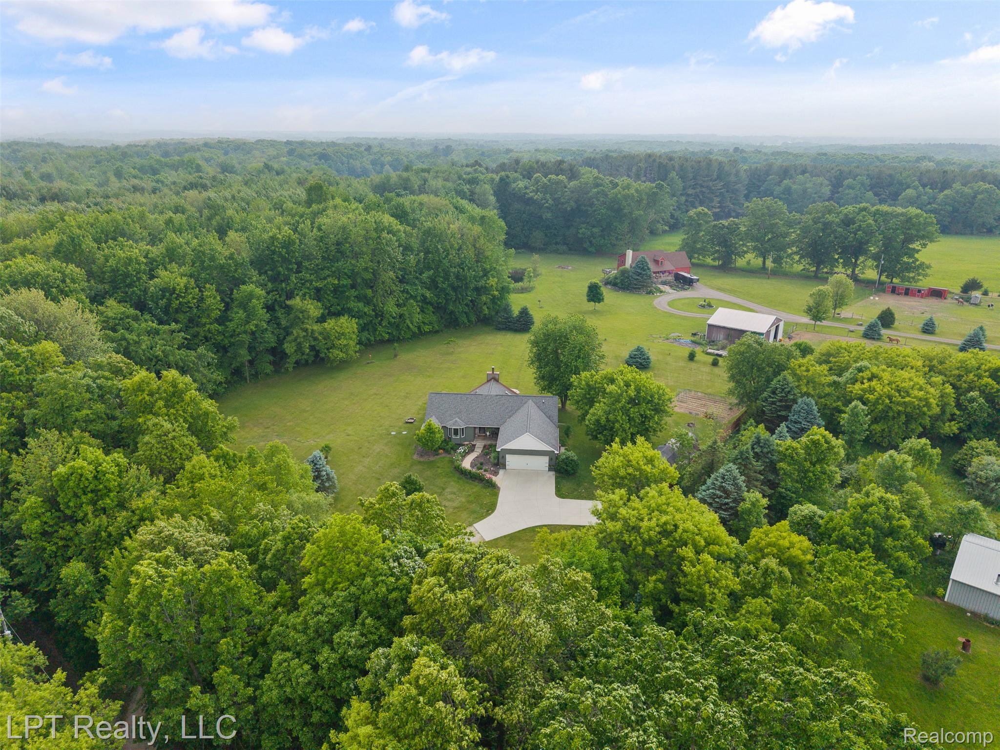 2588 East Jones Road Howell, MI 48855 - Photo 32 of 40 View from above of property with a heavily wooded area