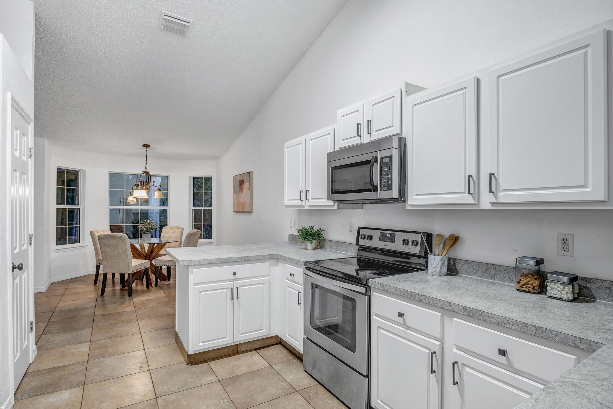 98 Roxboro Drive Palm Coast, FL 32164 - Photo 11 of 28 a kitchen with white cabinets and appliances