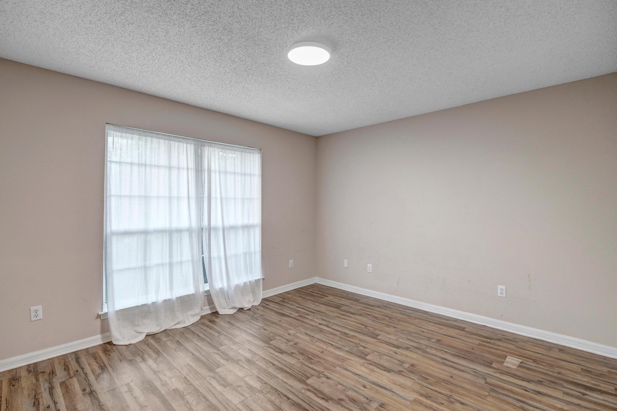 98 Roxboro Drive Palm Coast, FL 32164 - Photo 26 of 28 wooden floor in an empty room with a window