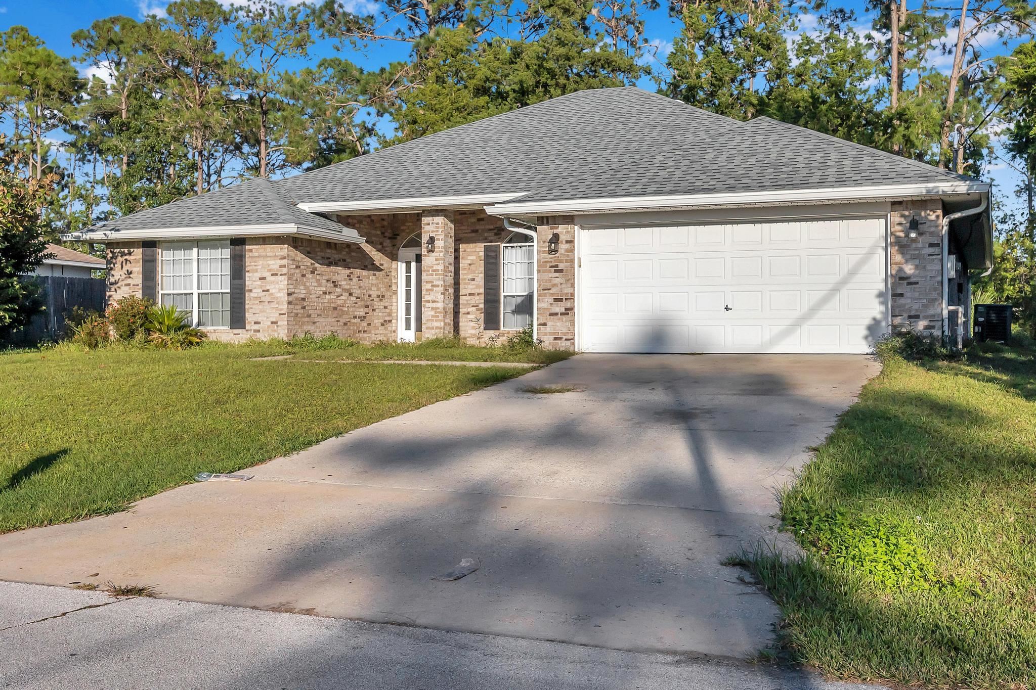 98 Roxboro Drive Palm Coast, FL 32164 - Photo 5 of 28 a view of a big house with a big yard and large trees
