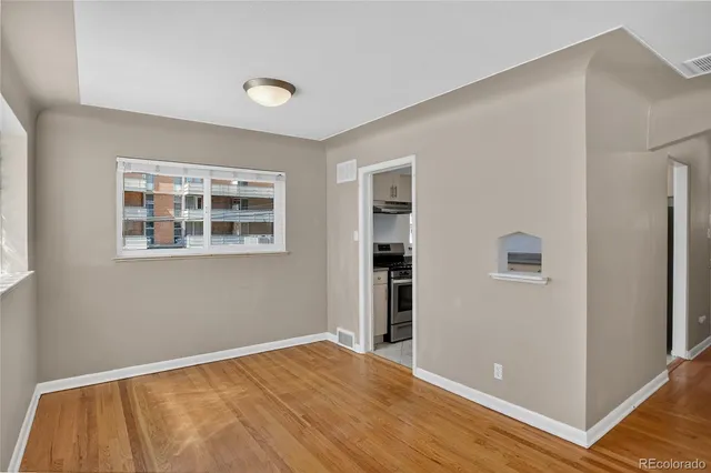 a view of empty room with wooden floor and windows