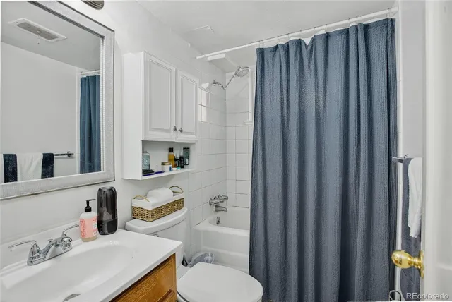 a bathroom with a sink a toilet and shower curtain