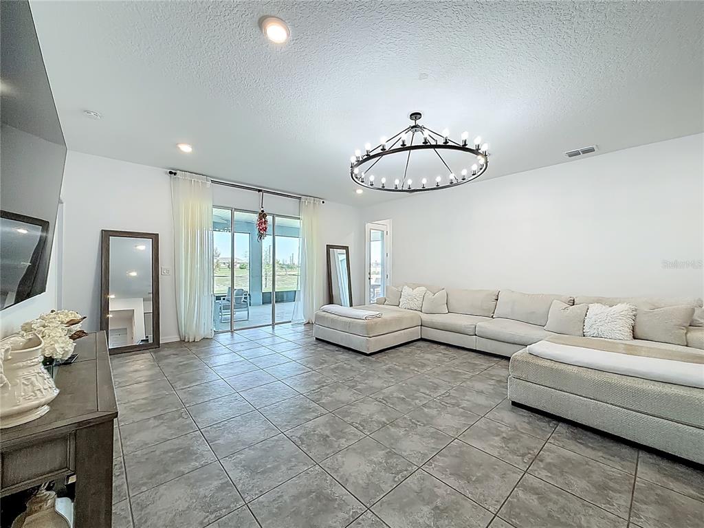 7429 Southwest 61st Street Ocala, FL 34474 - Photo 12 of 40 a living room with furniture and a flat screen tv