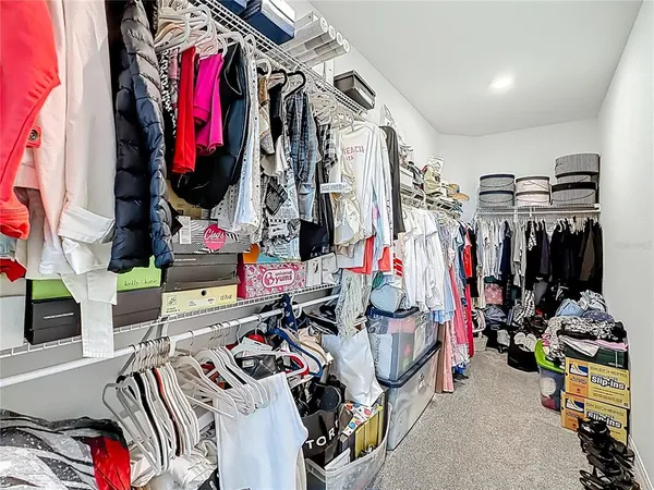 a view of walk in closet with clothes