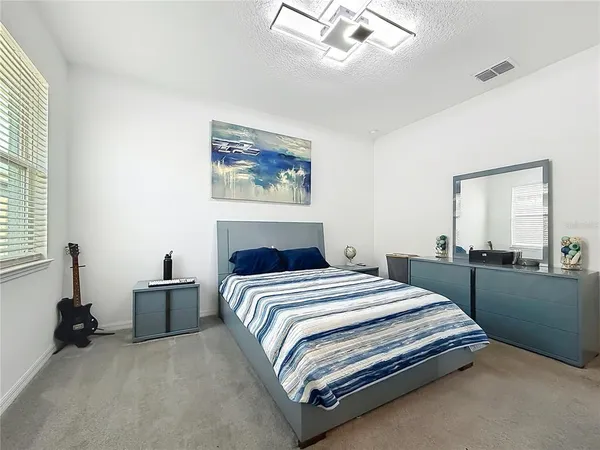 a bedroom with a bed and a large mirror