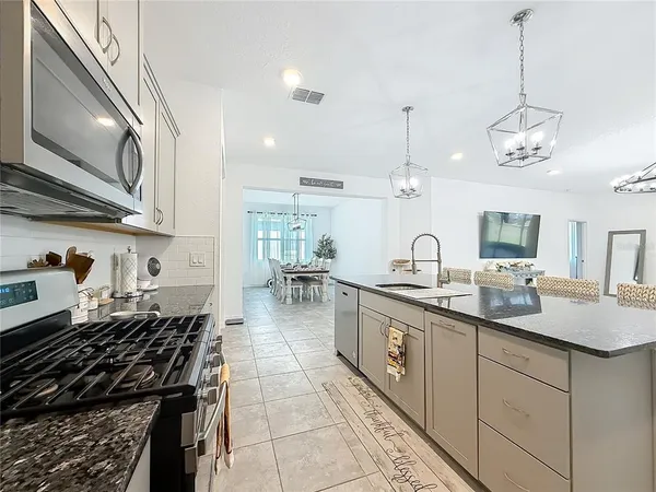 a kitchen with kitchen island granite countertop a sink and stove