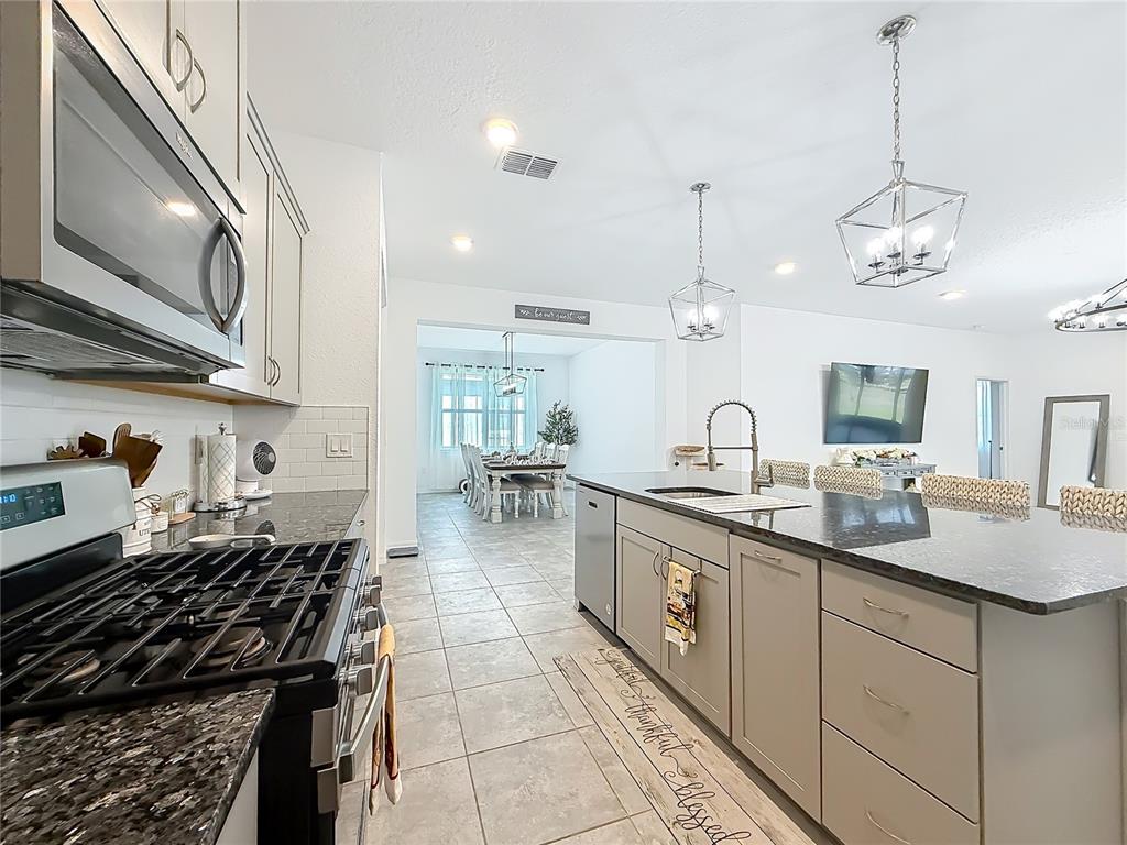 7429 Southwest 61st Street Ocala, FL 34474 - Photo 2 of 40 a kitchen with kitchen island granite countertop a sink and stove