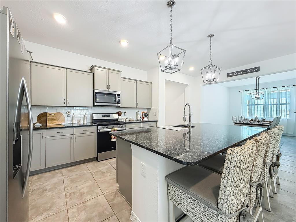 7429 Southwest 61st Street Ocala, FL 34474 - Photo 4 of 40 a kitchen with kitchen island granite countertop a sink a counter top space appliances and cabinets