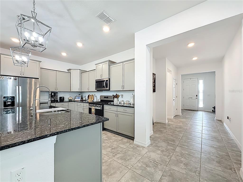 7429 Southwest 61st Street Ocala, FL 34474 - Photo 7 of 40 a kitchen with stainless steel appliances granite countertop a refrigerator a sink dishwasher a stove and white cabinets with wooden floor