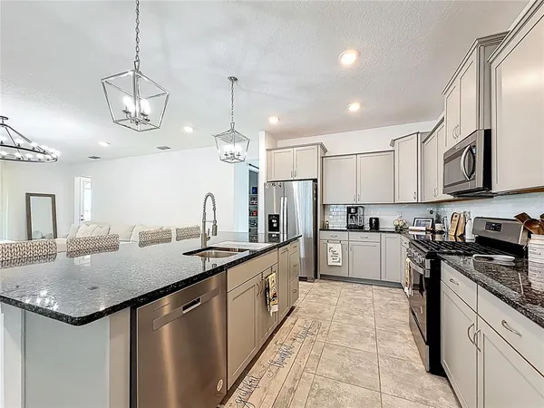 a open kitchen with stainless steel appliances granite countertop a sink and stove