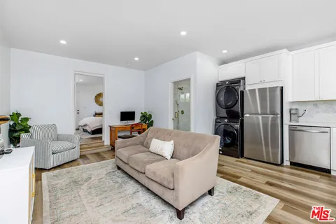 a living room with furniture a refrigerator and a couch