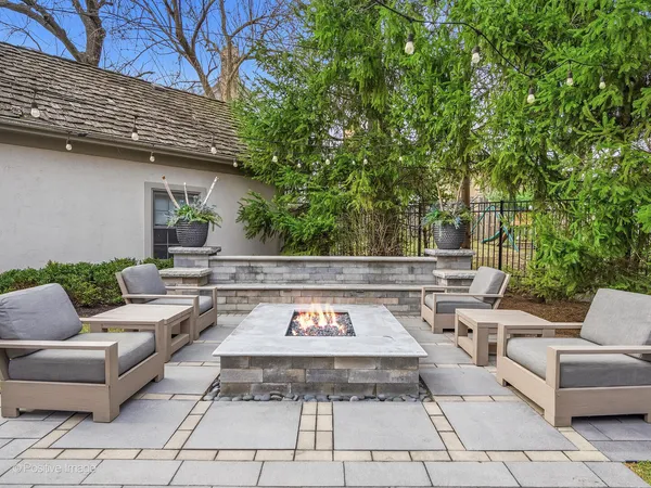 a view of a patio with couches and a table and chairs with wooden floor and fence