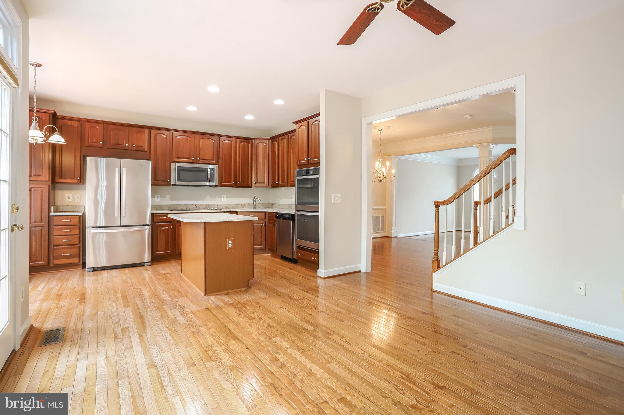 18546 Perdido Bay Terrace Leesburg, VA 20176 - Photo 13 of 57 a kitchen with stainless steel appliances granite countertop a refrigerator a stove a sink and a microwave