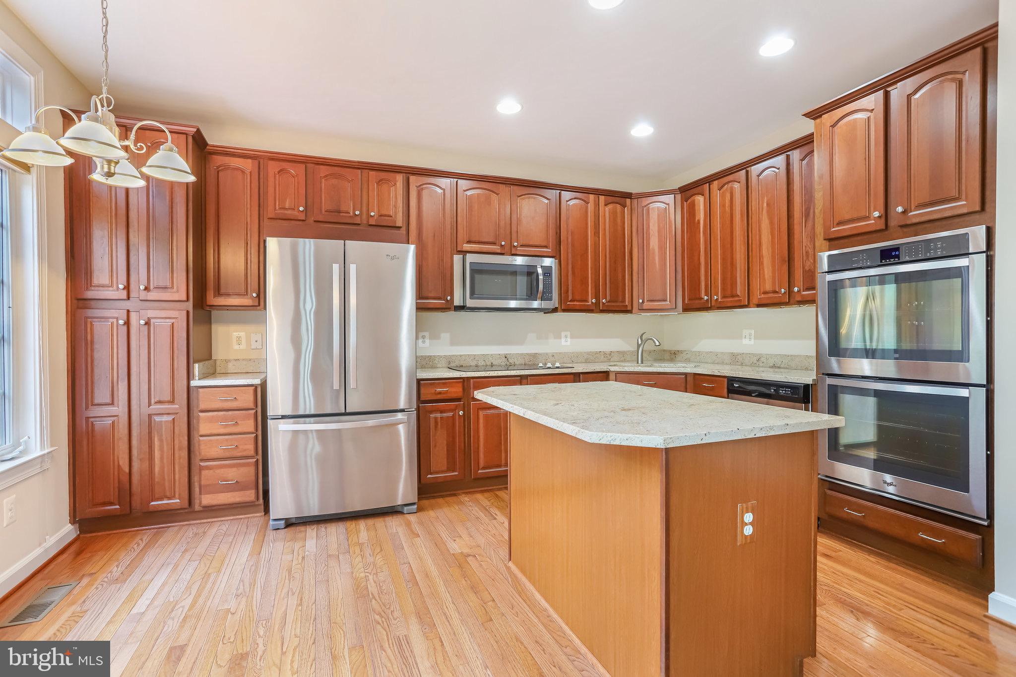 18546 Perdido Bay Terrace Leesburg, VA 20176 - Photo 16 of 57 a kitchen with wooden cabinets and stainless steel appliances