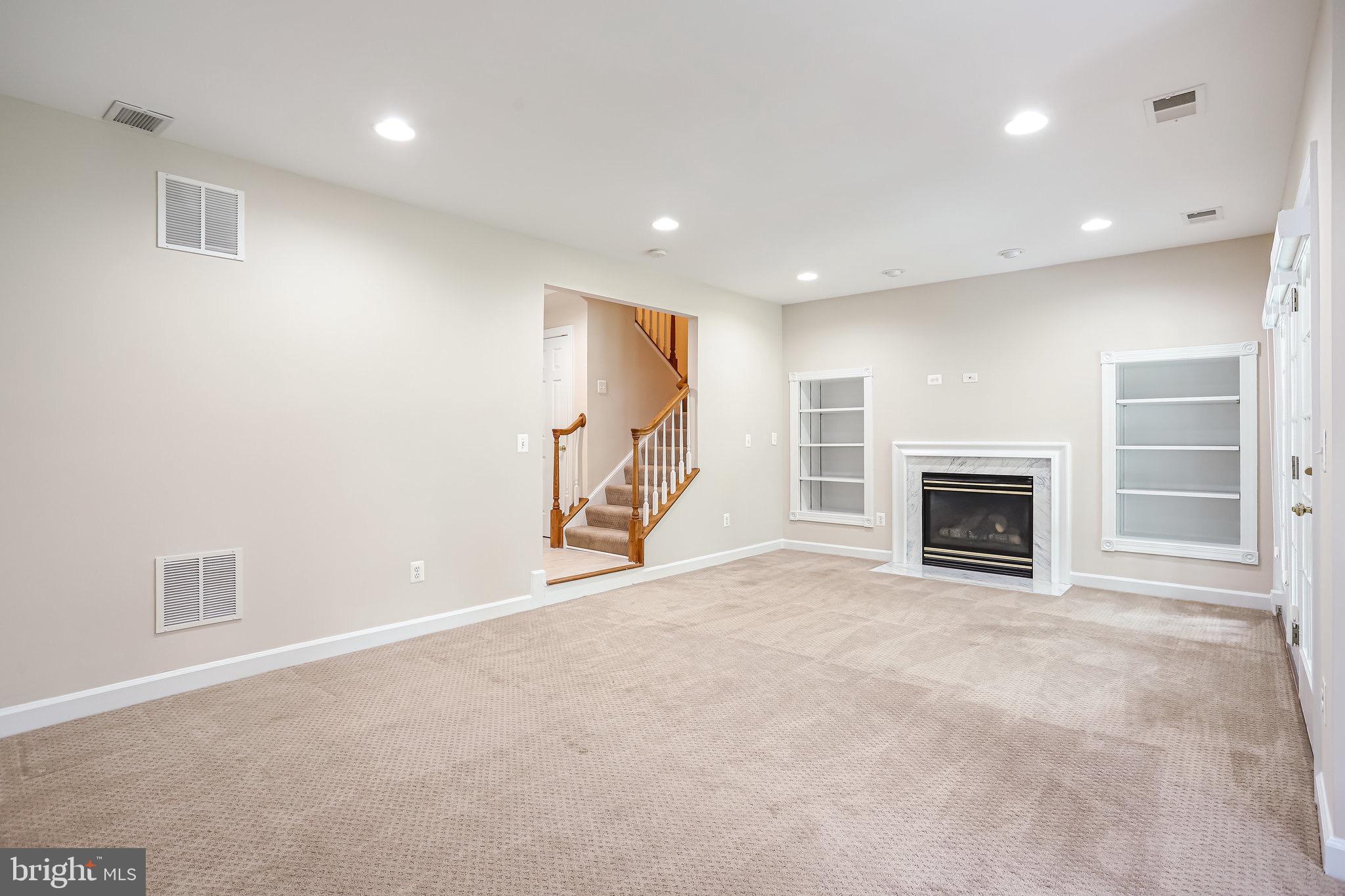 18546 Perdido Bay Terrace Leesburg, VA 20176 - Photo 34 of 57 an empty room with a fireplace and a chandelier