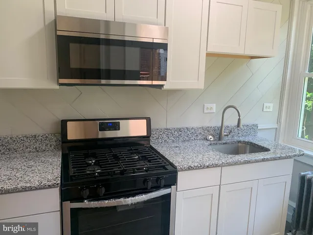 a kitchen with stainless steel appliances granite countertop white cabinets and black granite counter tops