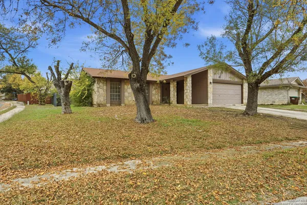 a front view of a house with a yard and trees