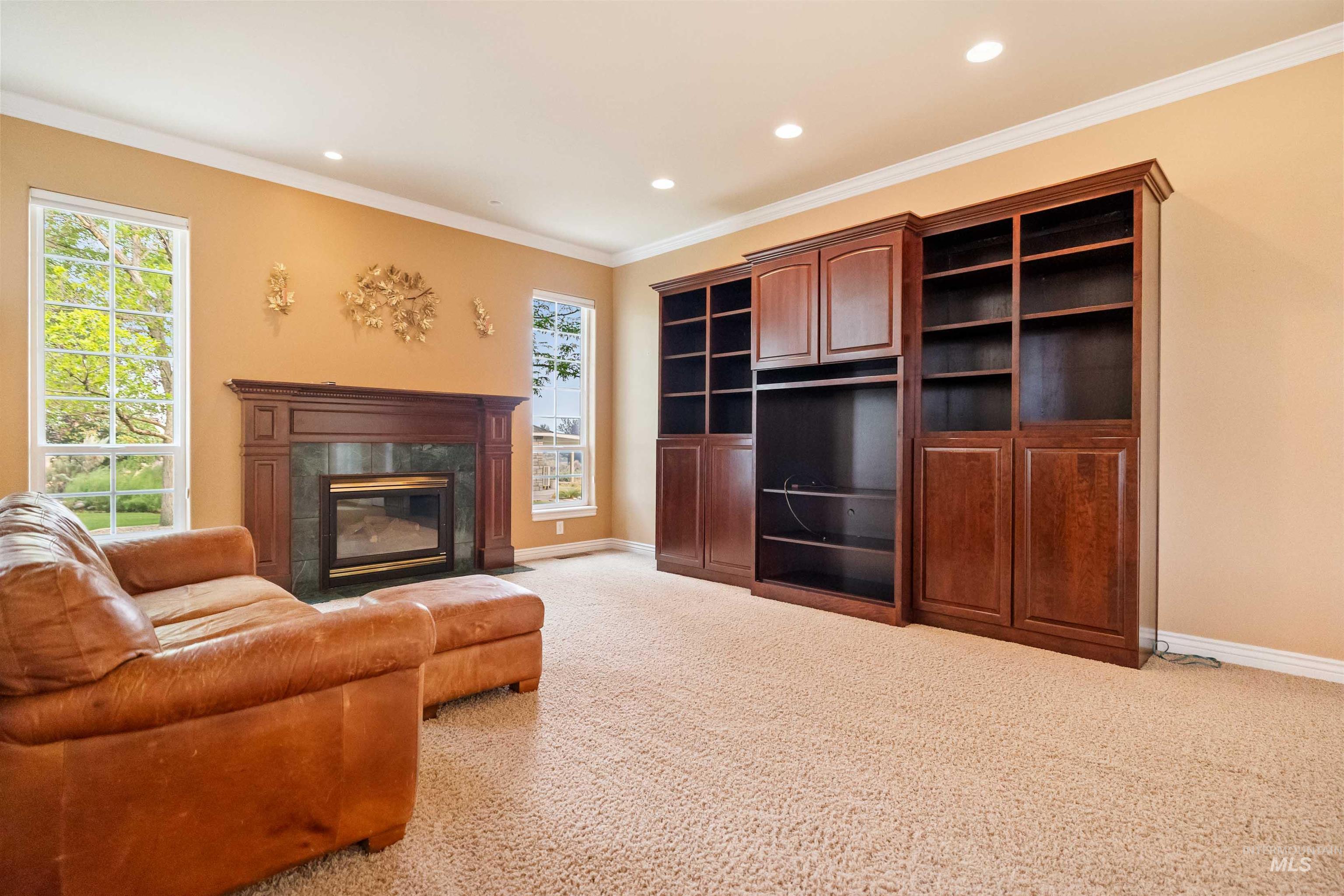 3404 Ridge Line Drive Kimberly, ID 83341 - Photo 15 of 50 Living area featuring a dark wood mantel fireplace with a dark stone surround, flanked by two tall windows