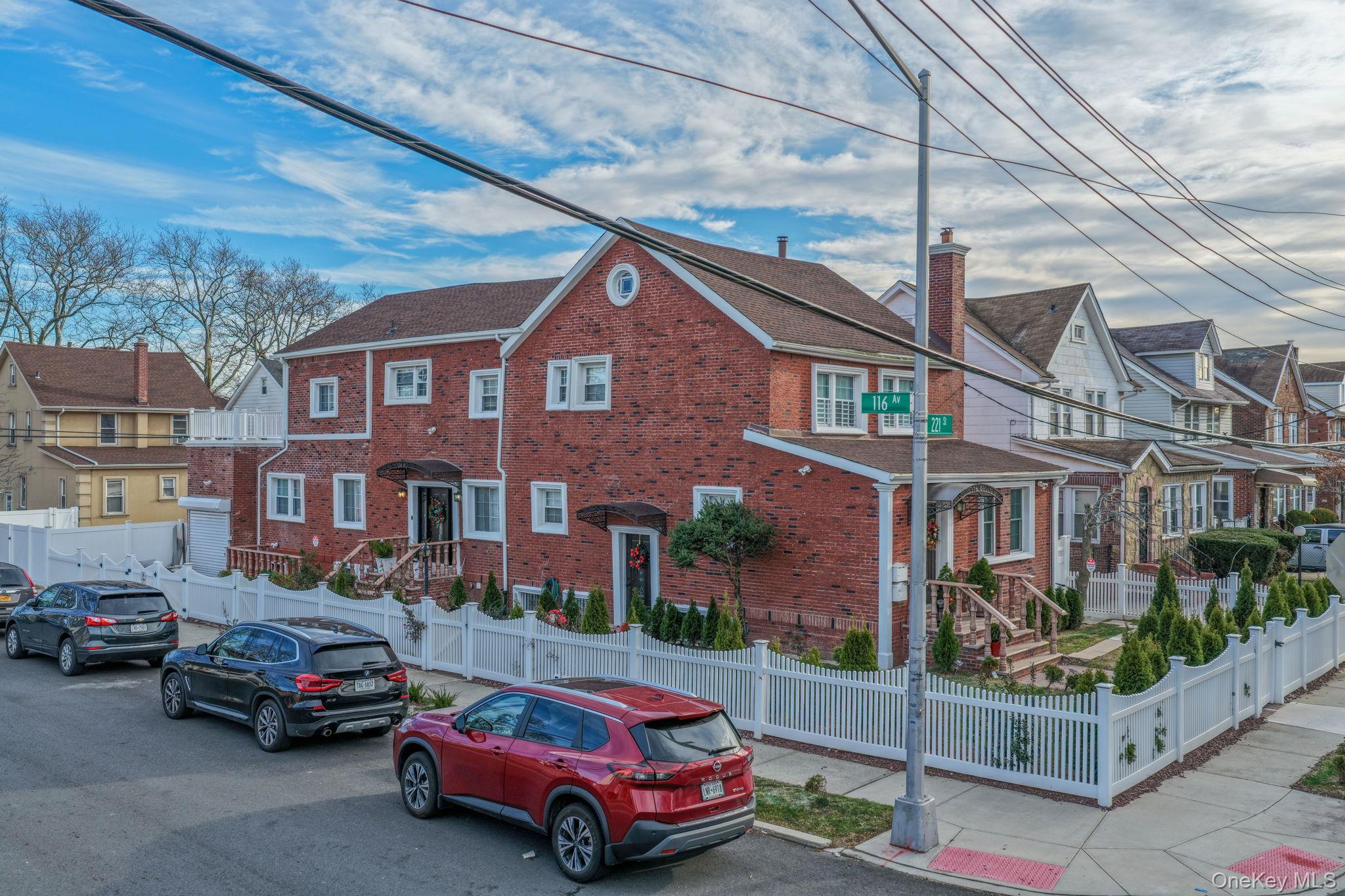 View of front of property featuring a fenced front yard, a residential view, and brick siding