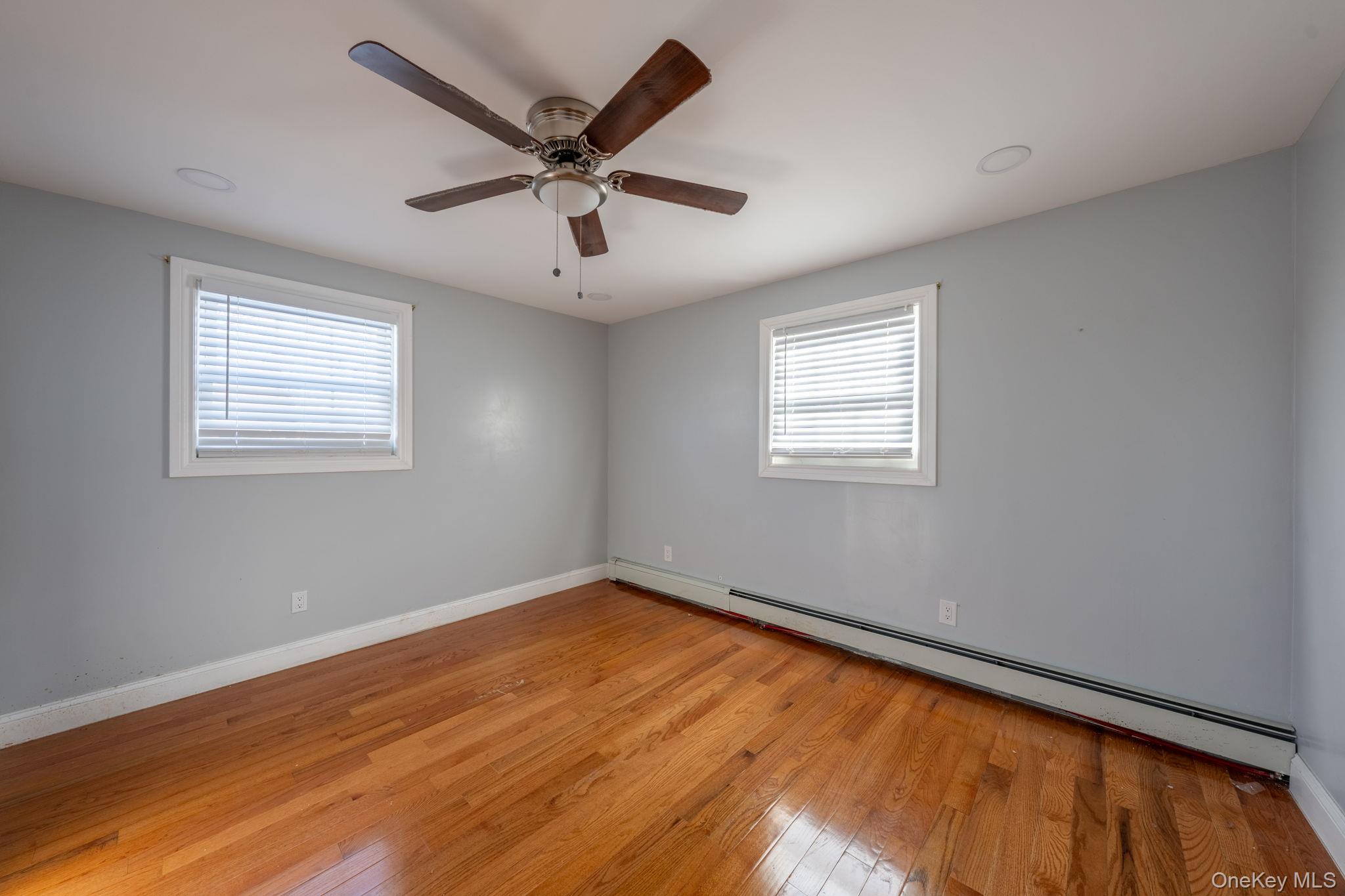116-01 221st Street Queens, NY 11411 - Photo 8 of 19 Empty room with a baseboard heating unit, light wood-type flooring, and ceiling fan