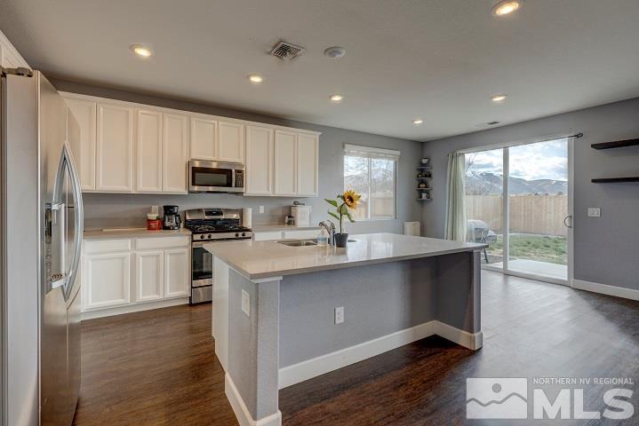 9405 Cape Drive Reno, NV 89506 - Photo 3 of 17 a kitchen with kitchen island granite countertop a sink cabinets and stainless steel appliances