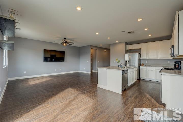 9405 Cape Drive Reno, NV 89506 - Photo 6 of 17 a view of a kitchen with kitchen island a sink wooden floor and a stove top oven