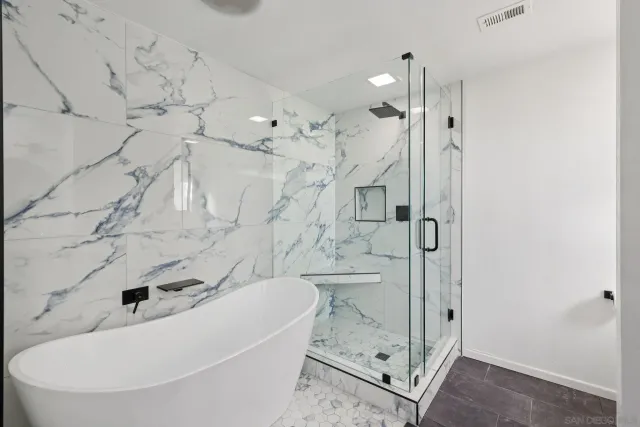 a bedroom with a large bed couch and a potted plant