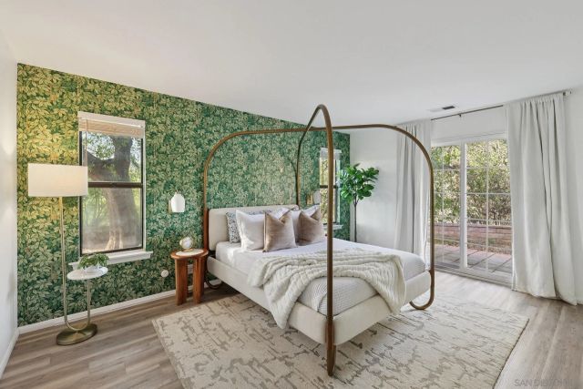 a bedroom with a large bed couch and a potted plant