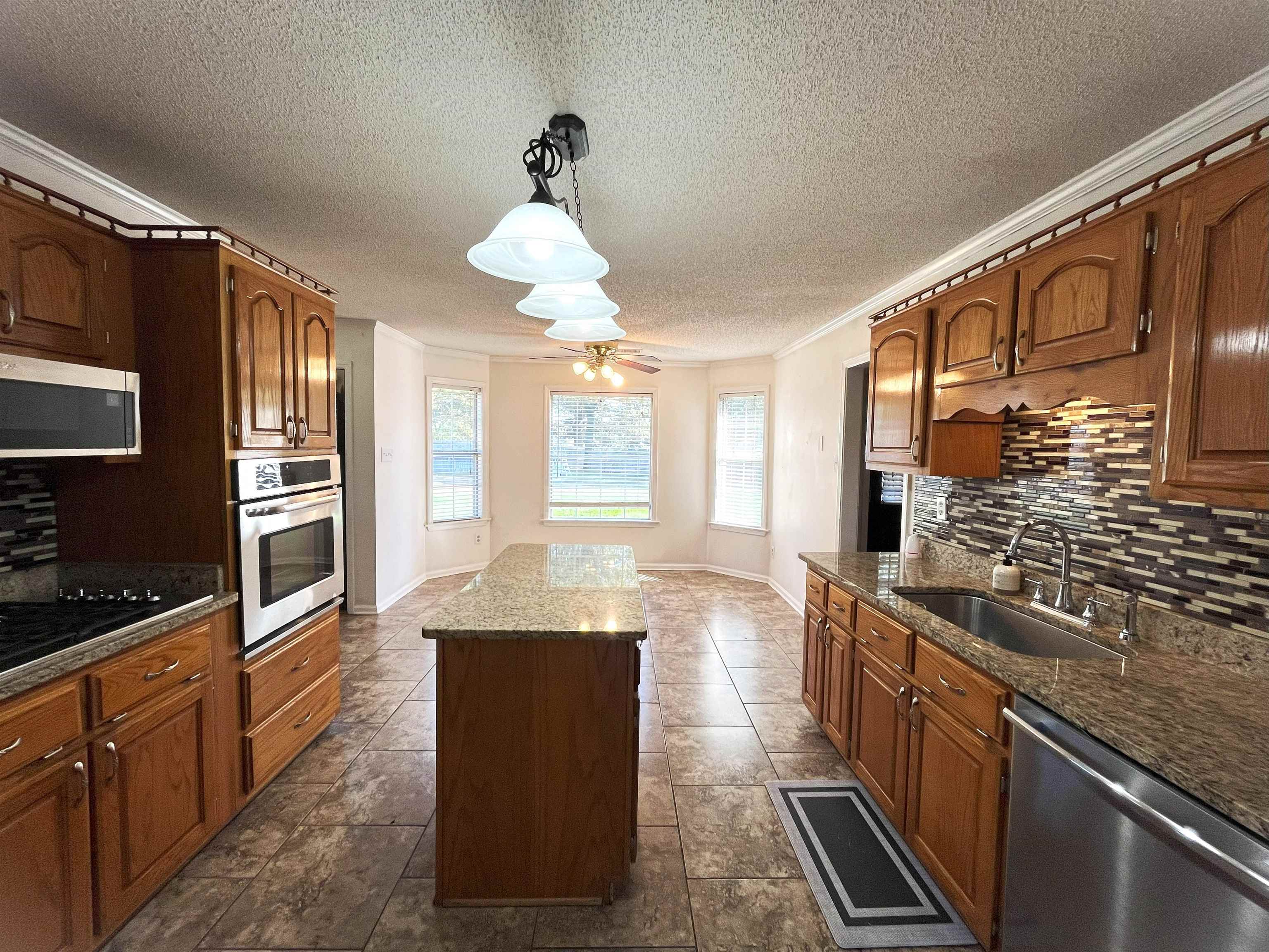 4020 Meade Lake Road Millington, TN 38053 - Photo 11 of 23 Kitchen featuring hanging light fixtures, ornamental molding, sink, backsplash, and stainless steel appliances