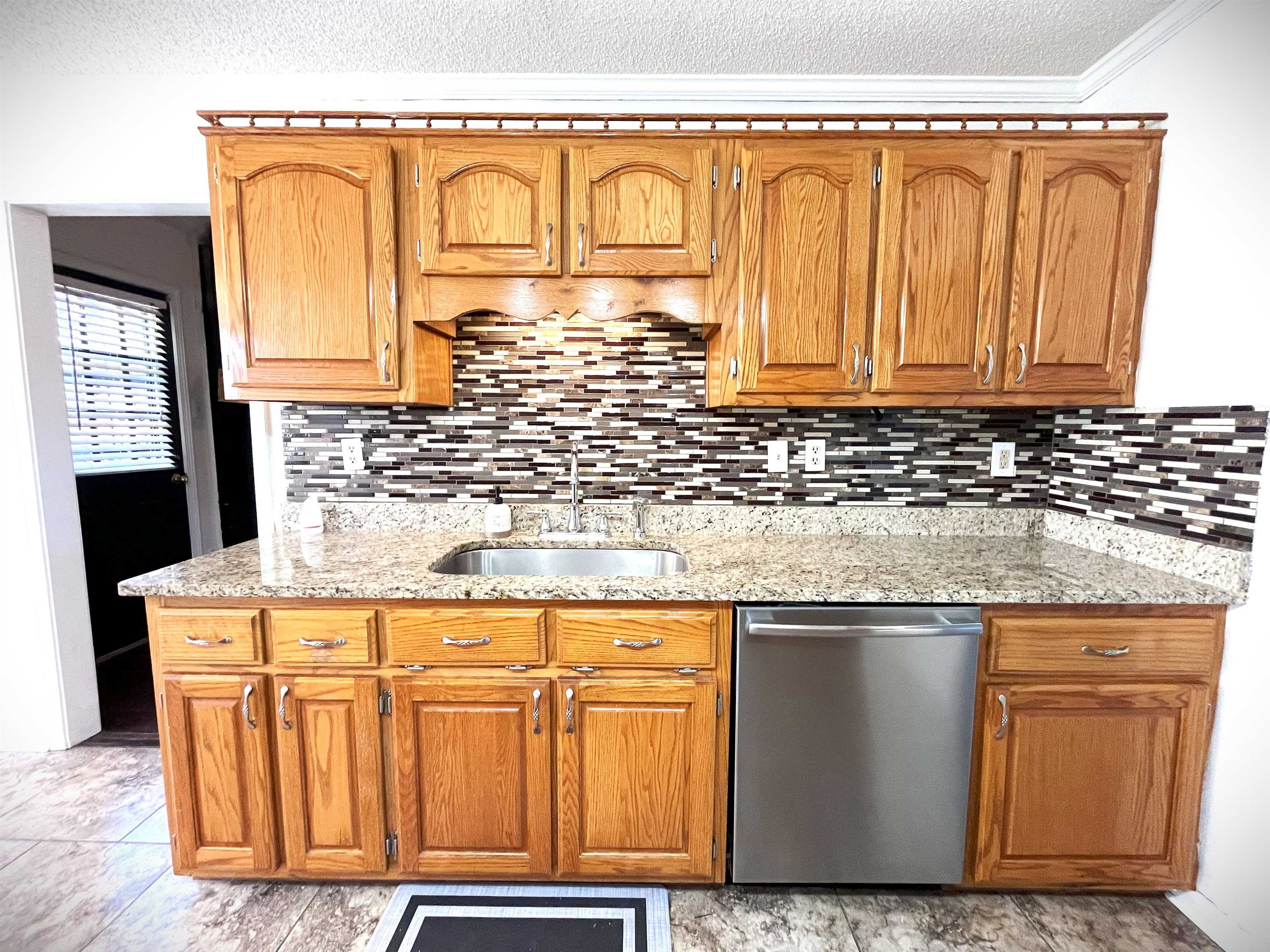 4020 Meade Lake Road Millington, TN 38053 - Photo 20 of 23 Kitchen with decorative backsplash, crown molding, sink, light stone counters, and dishwasher