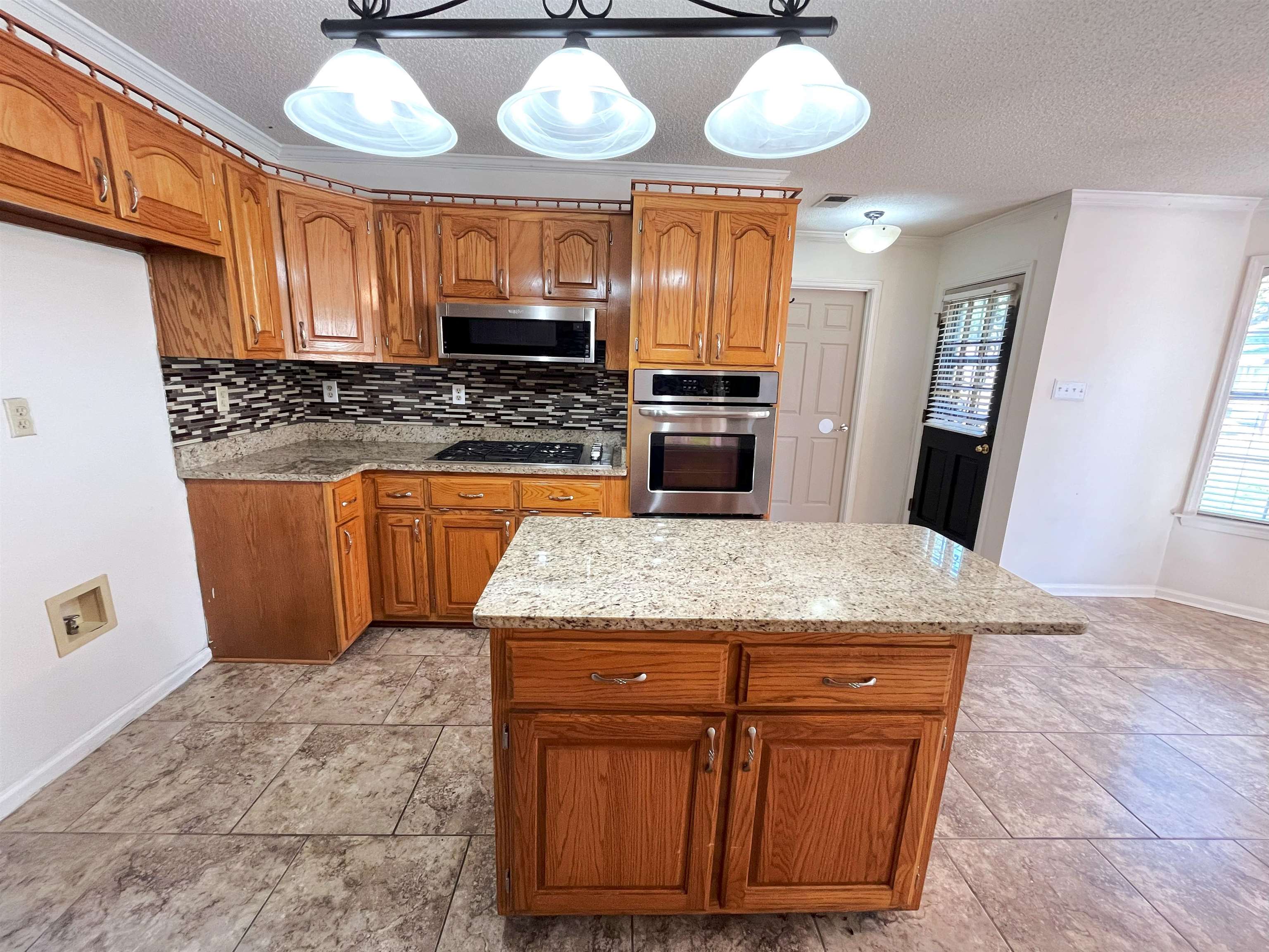 4020 Meade Lake Road Millington, TN 38053 - Photo 22 of 23 Kitchen with stainless steel appliances, hanging light fixtures, decorative backsplash, and a center island