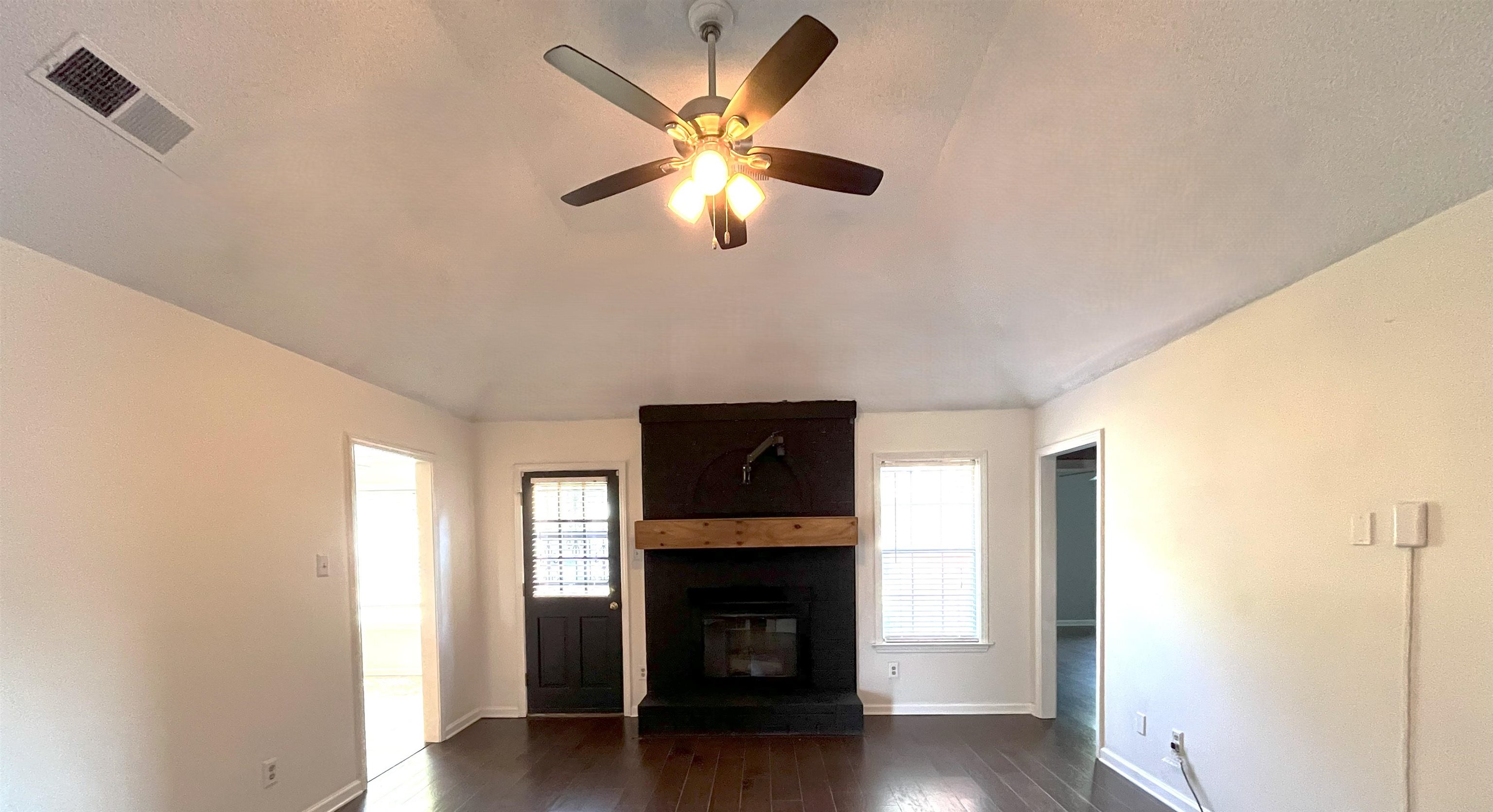 4020 Meade Lake Road Millington, TN 38053 - Photo 5 of 23 Unfurnished living room with dark wood-type flooring, lofted ceiling, a fireplace, and ceiling fan