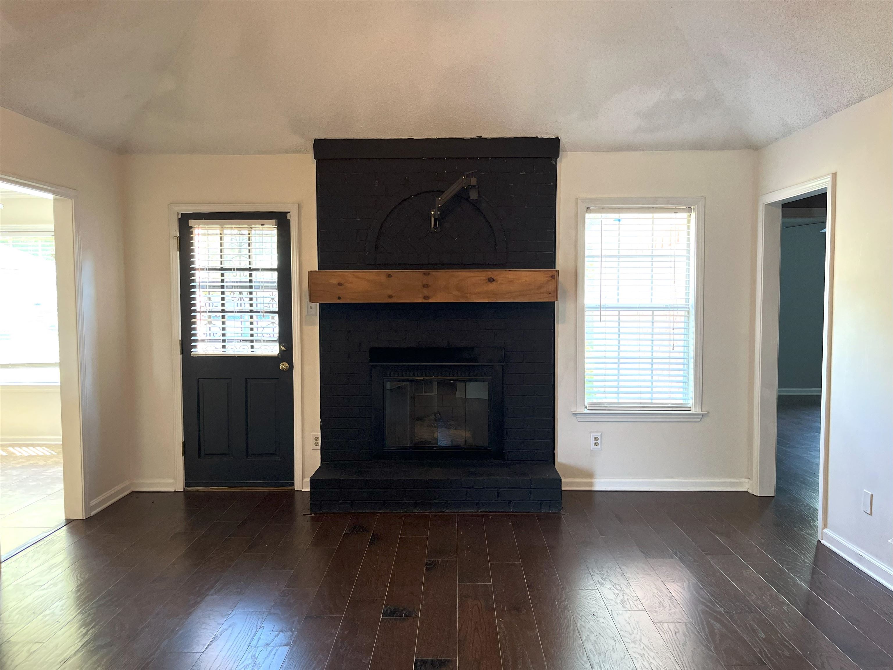4020 Meade Lake Road Millington, TN 38053 - Photo 6 of 23 Unfurnished living room with a fireplace, dark hardwood / wood-style floors, and a textured ceiling
