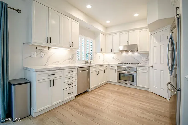 a kitchen with white cabinets and white appliances