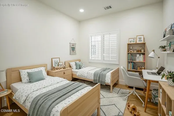 a bedroom with a bed and a potted plant