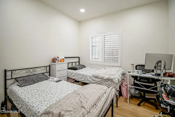 a bedroom with a large bed and a potted plant