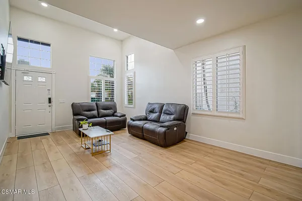 a living room with furniture and a hard wood floor