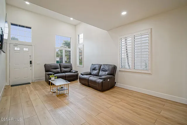 a living room with furniture and a hard wood floor