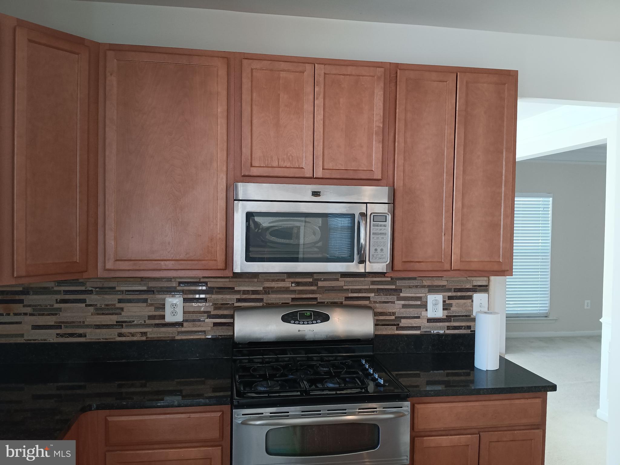 9707 Risen Star Drive Upper Marlboro, MD 20772 - Photo 19 of 35 a kitchen with granite countertop wood cabinets and stainless steel appliances