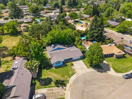 an aerial view of a house with a yard and greenery