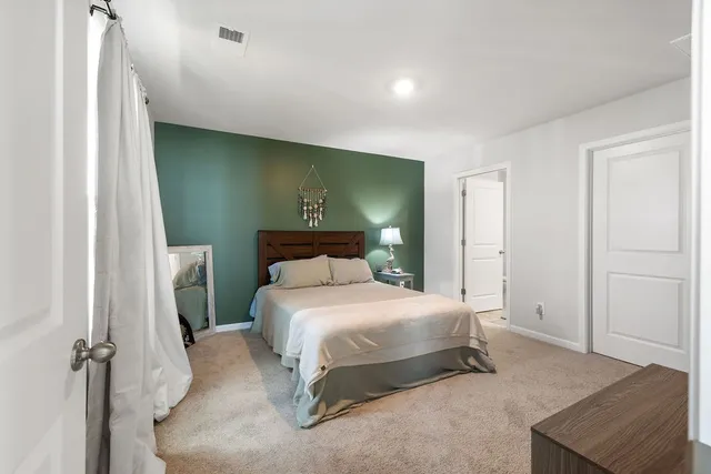 a bedroom with a bed and a painting on the wall