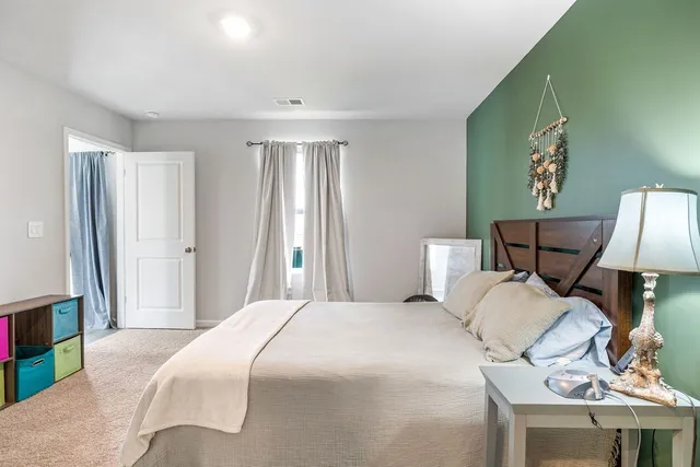 a bedroom with a bed and a lamp