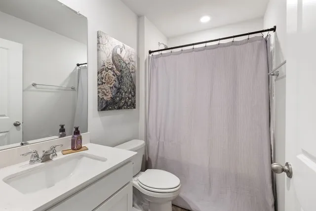 a bathroom with a sink a toilet and shower