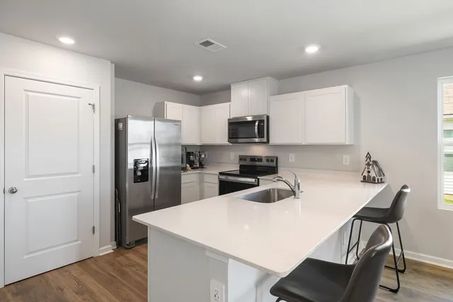 a kitchen with kitchen island a refrigerator stove microwave and cabinets
