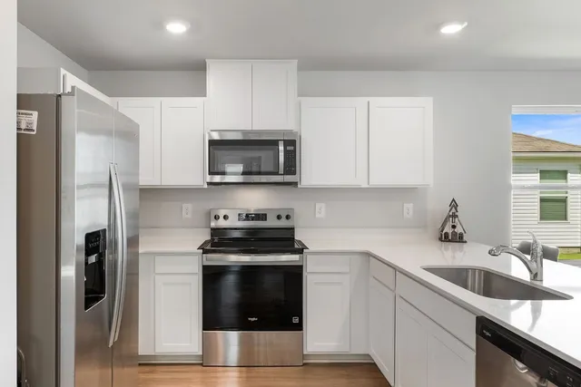 a kitchen with stainless steel appliances a stove a sink and a refrigerator