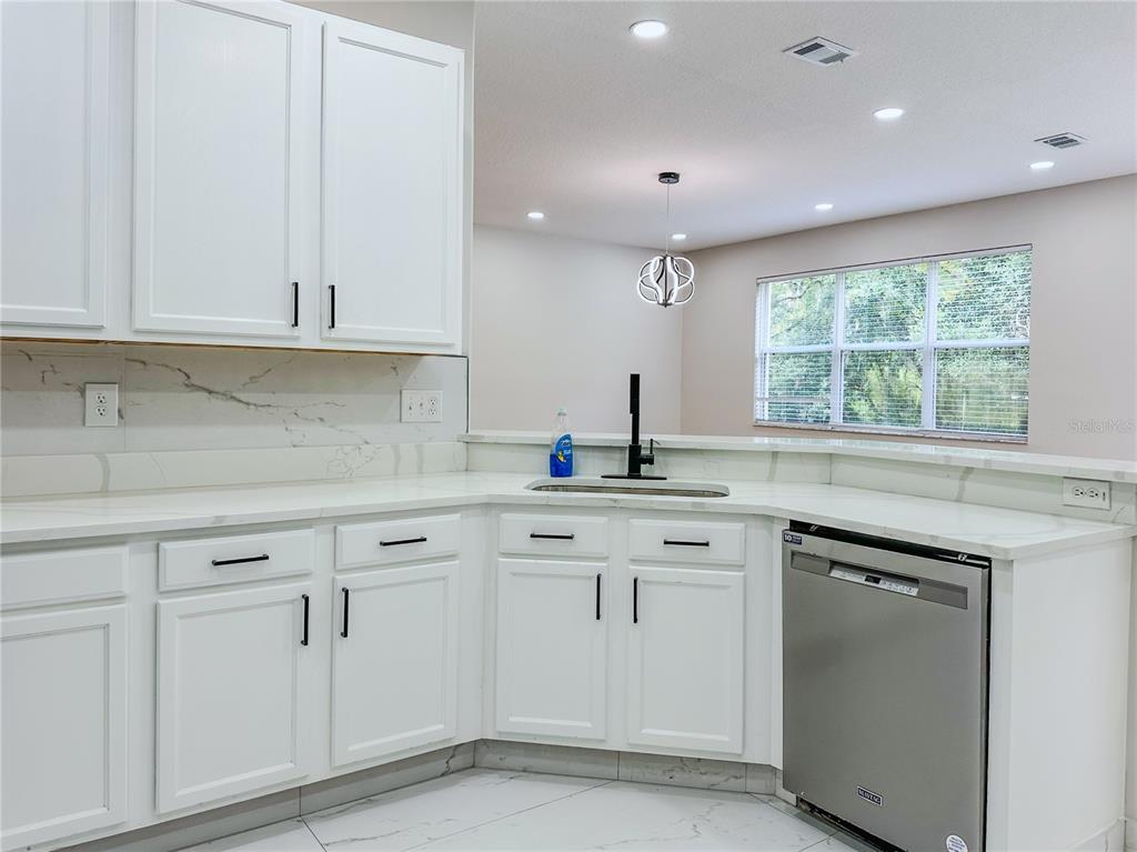 7322 Bridgeview Drive Wesley Chapel, FL 33545 - Photo 18 of 75 a kitchen with white cabinets and a window