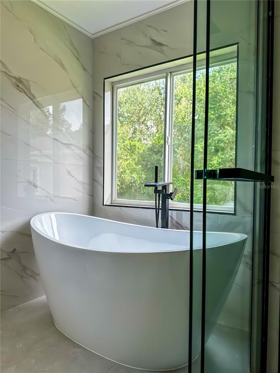 7322 Bridgeview Drive Wesley Chapel, FL 33545 - Photo 35 of 75 a bath tub sitting in a bathroom next to a window