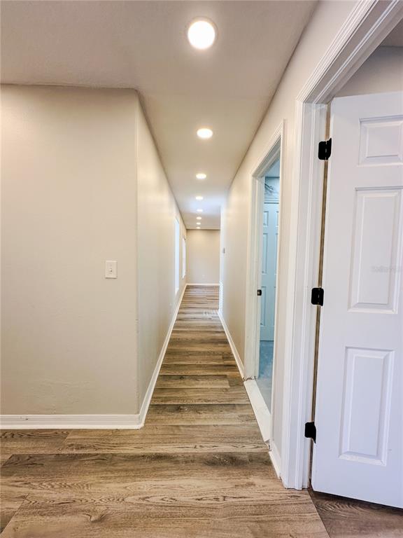 7322 Bridgeview Drive Wesley Chapel, FL 33545 - Photo 41 of 75 a view of a hallway with wooden floor and staircase
