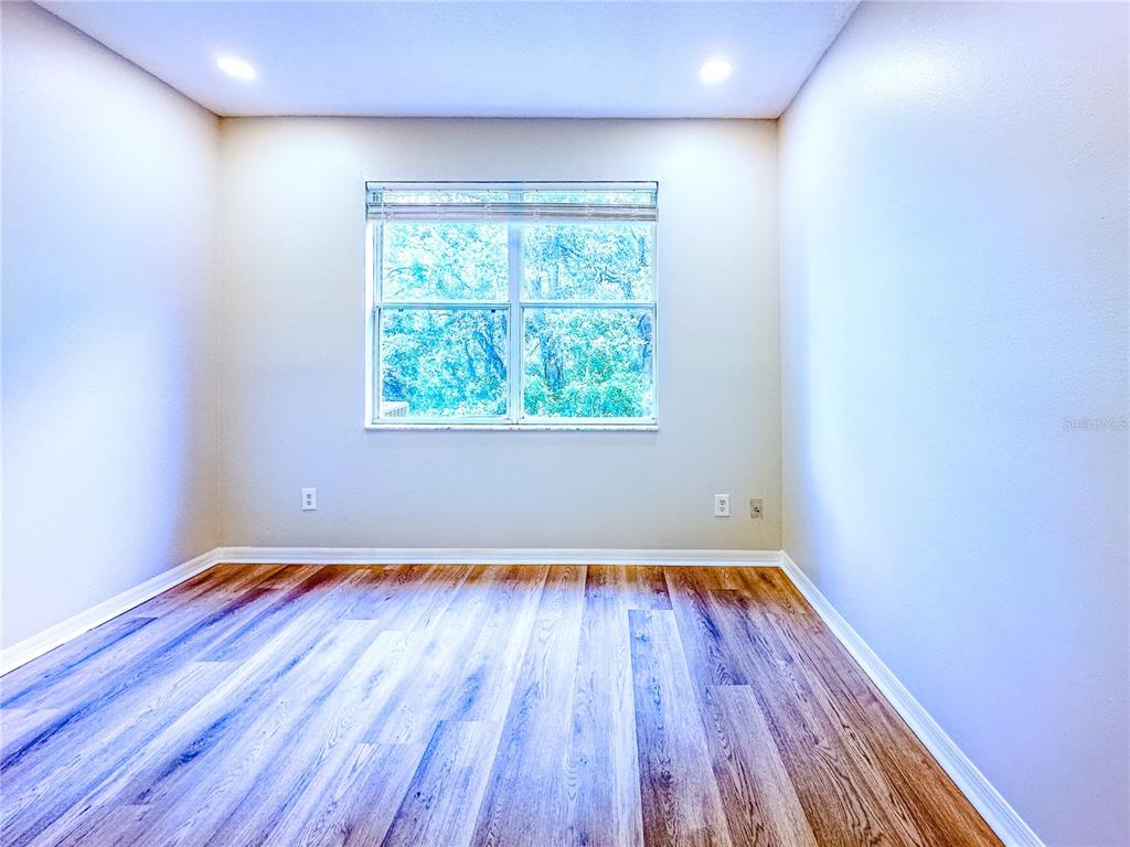 7322 Bridgeview Drive Wesley Chapel, FL 33545 - Photo 56 of 75 a view of an empty room with wooden floor and a window